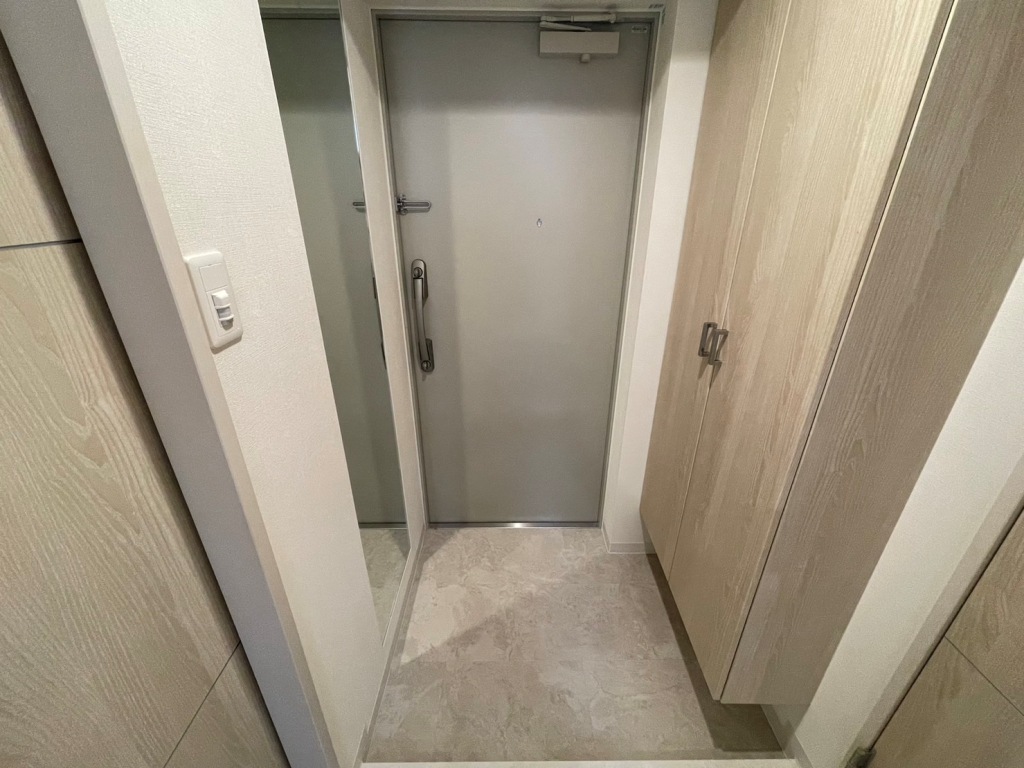 グランディア大阪ノースの玄関:ドアは防犯性の高いディンプルキーダブルロック、玄関入って右手には姿鏡、左手には天井高の両開きシューズボックスが設置されている。